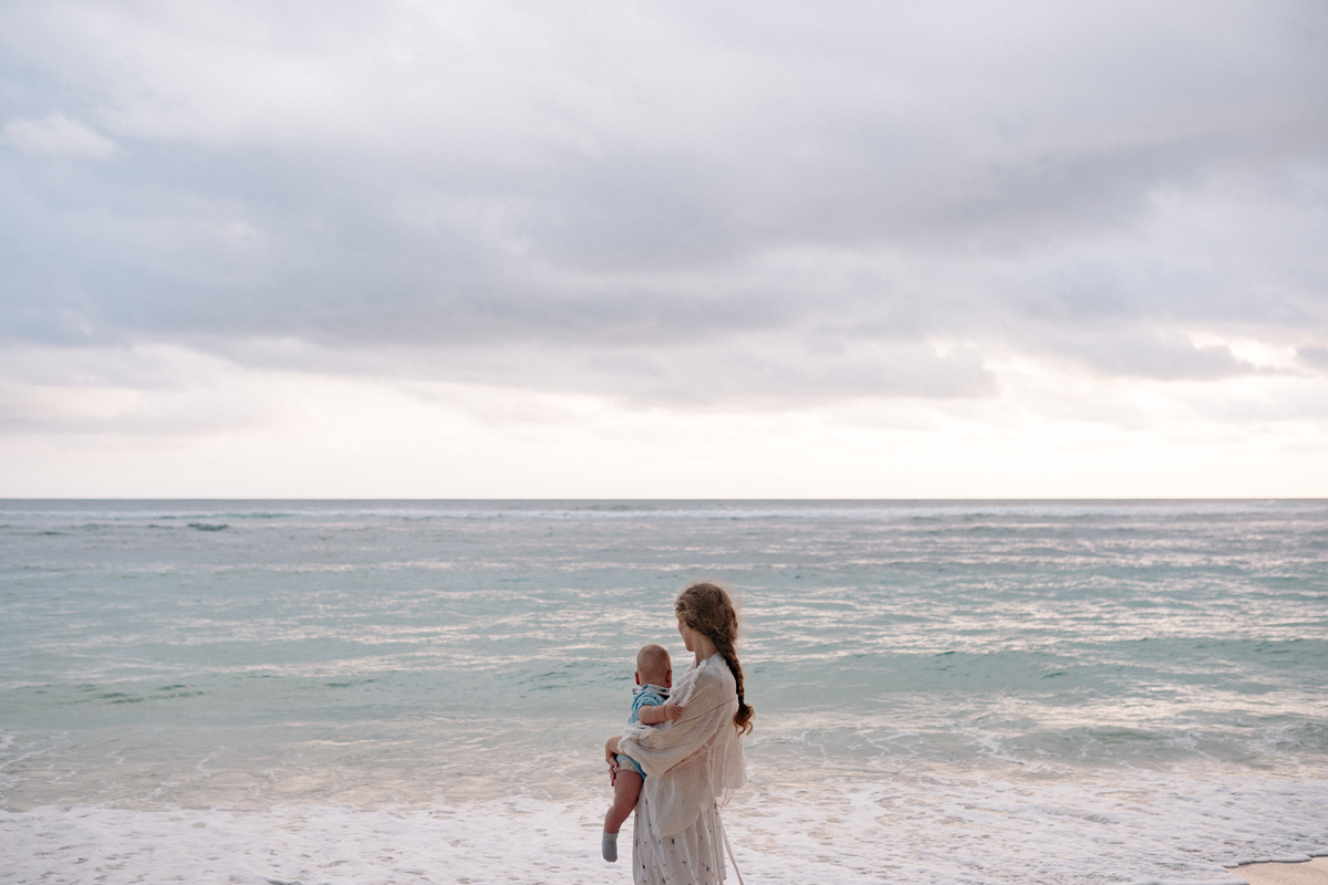 Mother Carrying Her Baby at the Beach
